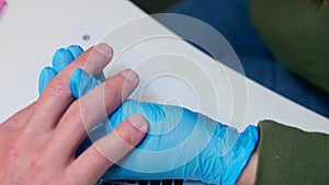 Close up view of man's hand with soft pink skin. Manicurist removes dust from hands usinf pink brush. Meterosexual cares