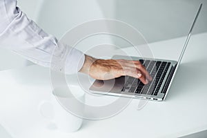 Close up view of man`s hand that typing on laptop in the office