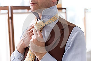 Close up view of man tieing tie