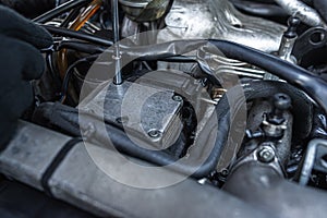 Close-up view of a mechanic using a tool to work on a car engine