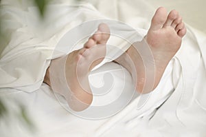 Close up view of men feet isolated on white sheet background laying on bed. Peeling flaky dry.