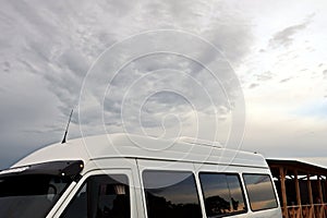 Close-up view of a minibus and cars standing on the shore of a lake. The reflection in the windows of the car.