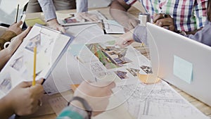 Close-up view of mixed race group of people working at the table. Team discussing architectural design, start-up company