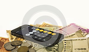 Close up view of Mobile Phone Calculate and new Indian rupees and coin