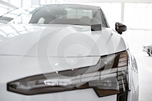 Close-up view of modern keys lying on the hood of a new car.