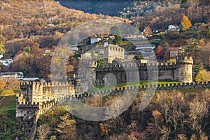 Close up view of Montebello castle ruin from Castelgrande Castle on a sunny autumn day with colourful tree and green grass,