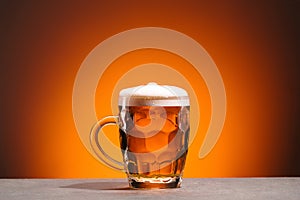 close up view of mug of cold beer on orange backdrop