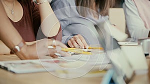 Close-up view of multiethnic group of people working at the table. Creative business team actively discussing new idea.