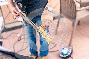 Close up view of a musician tuning his electric guitar on stage