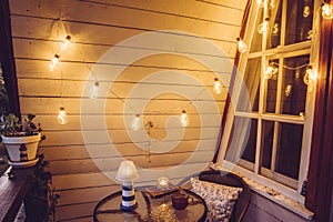 Close up view of nautical theme home balcony at night with string light bulbs.