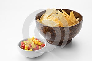 Close up view of nice red salsa and corn chips on white background.