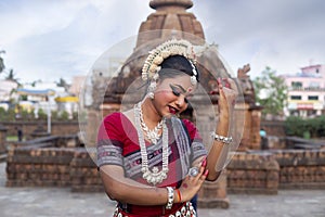 Close up view of Odissi dancer posing in front of Mukteshvara temple. Classical Dance