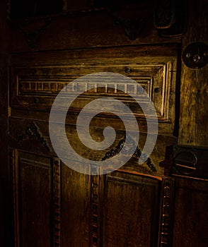 Close up view of old antique wooden door inside dark room. Selective focus
