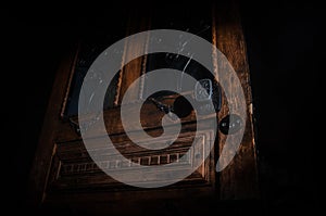 Close up view of old antique wooden door inside dark room. Selective focus