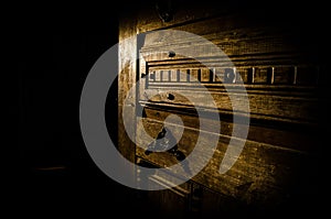 Close up view of old antique wooden door inside dark room. Selective focus