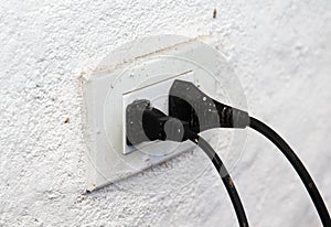 The old electrical outlets socket with plug on wall