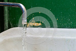 Close-up view of old stained water tap with selective focus and background blur
