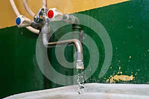 Close-up view of old stained water tap with selective focus and background blur