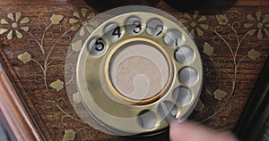 Close-up view on an old style telephone dial. Rotating numbers by finger.