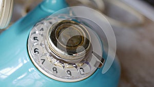 Close up view of old style telephone dialing. Antique blue telephone. Rotating numbers 911 with your finger. Old