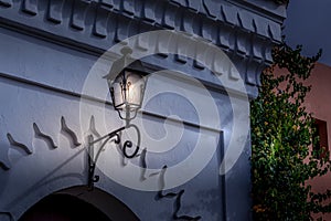 Close up view of an old traditional street lamp hanging over city entrance.