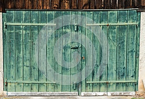 Close up view of an old vintage rustic green wooden barn door on a wooden shed