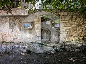 Close up view of old wooden door and high stone fence