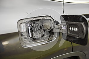 Close up view of an open hatch in an electric car for charging it.