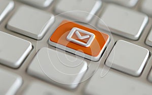 Close up view of an orange email button on a computer keyboard. Email marketing or newsletter concept