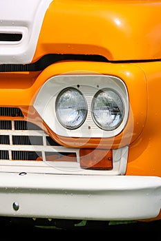 Close up view of orange and white vintage mini van head lamp