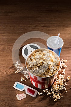 close up view of paper bucket with popcorn, soda drink, 3d glasses and retor cinema tickets on wooden tabletop