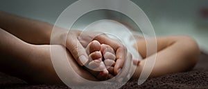 Close up view of parent hands holding tiny feet newborn baby