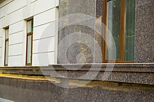 Close up view of part of a building facade with the surface of granite wall. Natural stone materials