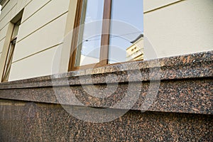 Close up view of part of a building facade with the surface of granite wall. Natural stone materials