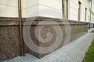 Close up view of part of a building facade with the surface of granite wall. Natural stone materials