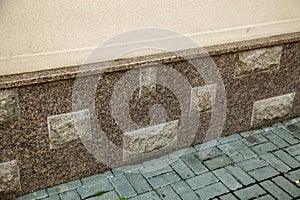 Close up view of part of a building facade with the surface of granite wall. Natural stone materials