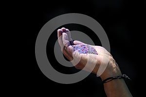 Close-up view of people holding colorful powder in hands at holi festival