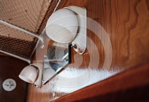 Close-up view of period style electrical lights seen within a first class railway carriage of the 1950s.
