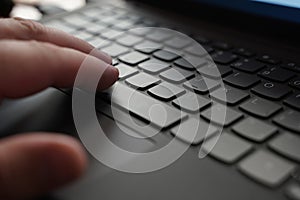 A close-up view of a person focusing on typing on a laptop keyboard