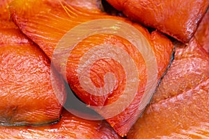 Close up view of piece cold smoked salted Pacific red fish Chinook Salmon. Prepared, ready-to-eat Pacific seafood. King