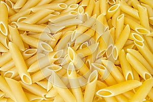 Close up view on a pile of yellow penne pasta