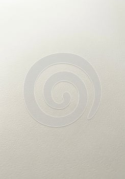 A close-up view of a plain, light beige surface with a subtle texture. The material is