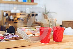 close-up view of plastic cups and tasty cookies on wooden counter