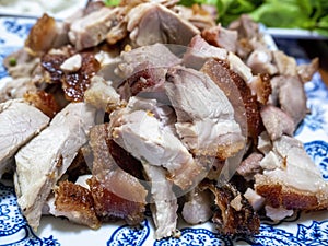 Close-up view of a plate of succulent Chinese crispy skin roast pork pieces