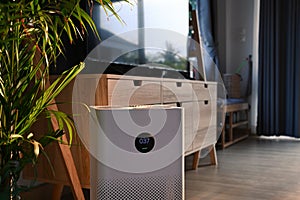 Portable air purifier on wooden floor in comfortable home for improve air quality and healthy life. photo