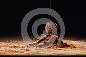 Close up view of pouring caramel onto heap made of truffle and chocolate bars