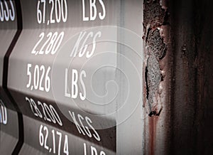 Close-up view of printed weights seen on the door of a shipping container in dock.