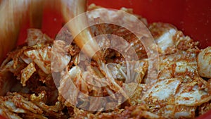 close up view process of making kimchi in big bowl using hand. Korean pickles, kimchi. Woman hand mixing vegetables ,kimchi sauce