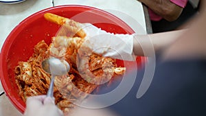 close up view process of making kimchi in big bowl using hand. Korean pickles, kimchi. Woman hand mixing vegetables ,kimchi sauce