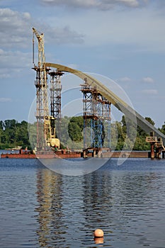 Close-up view the process of mounting steel structures for construction of a new pedestrian bridge over river